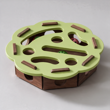 Close-up of a belled ball in the PuzzleFurr wooden track, held so it cannot be lost